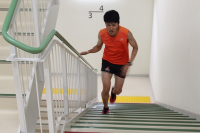 11階建て理大A1号館を駆け上がる吉井さん