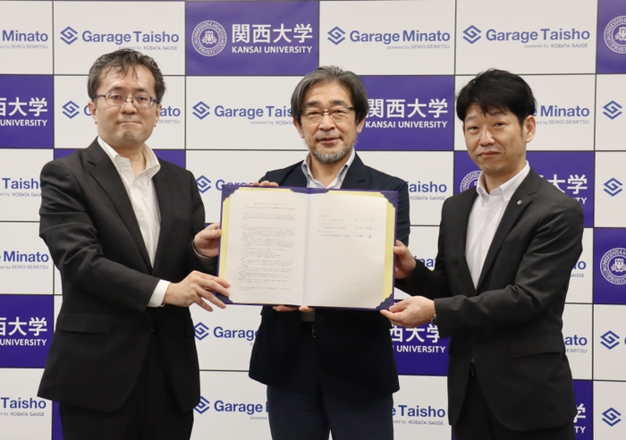 連携締結書を手にする3者の代表（左：Garage Taisho 木幡巌、中央：関西大学 イノベーション創生センター長 石川正司教授、右：Garage Minato 高満洋徳氏）