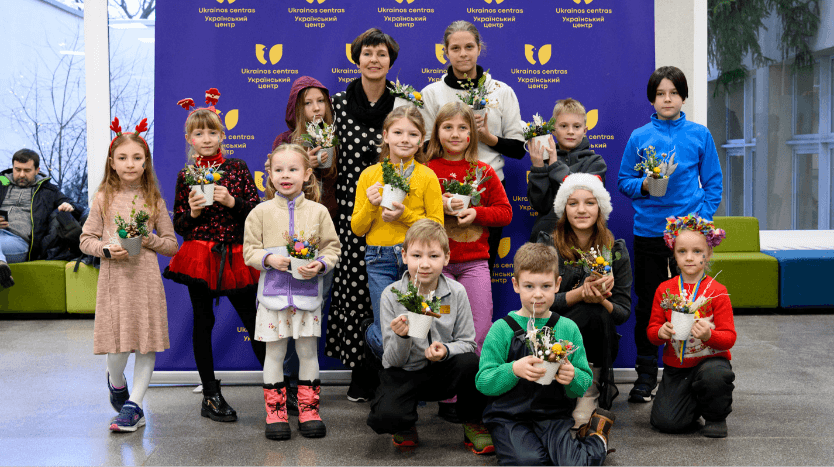 完成したクリスマス・デコレーションとともに立つウクライナ難民の子どもたち