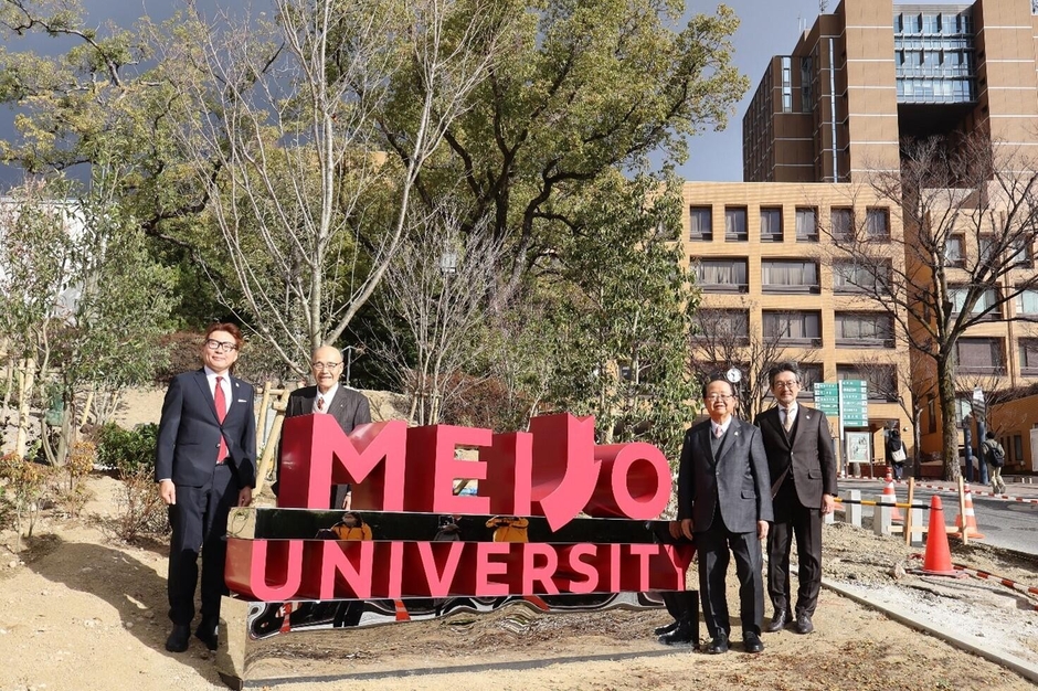 モニュメントで記念撮影する立花前理事長(右から2人目)ら