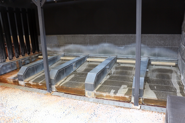 露天風呂エリアにある「寝床」(側面のボタンを押すと水が流れます)