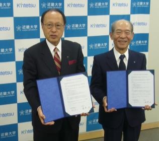 近鉄百貨店　代表取締役社長執行役員　髙松啓二（左）と近畿大学学長　塩﨑均（右）
