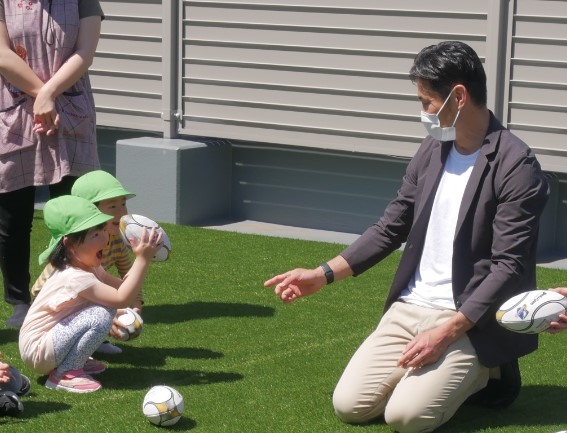 (子供用ラグビーボールを渡す廣瀬氏)