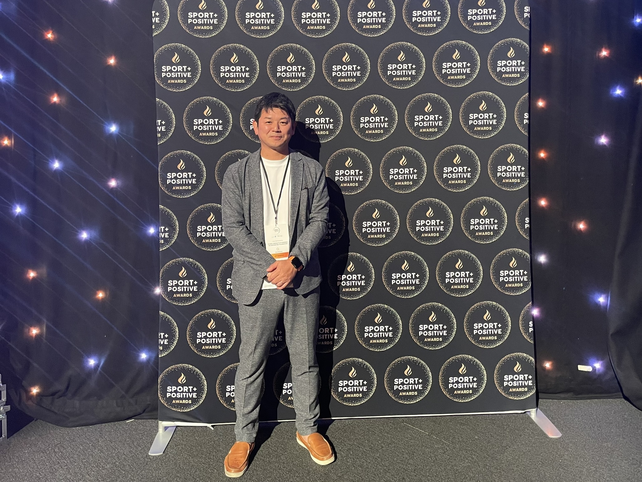 Summit内表彰式会場内のSport Positive Awardsパネル前にて代表理事松下