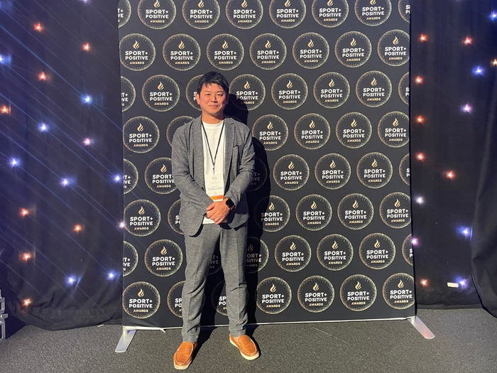 Summit内表彰式会場内のSport Positive Awardsパネル前にて代表理事松下