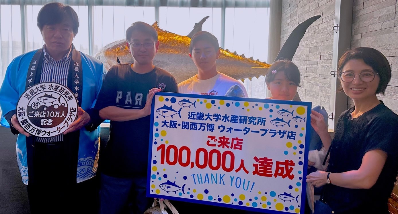 近畿大学水産研究所 大阪・関西万博ウォータープラザ店 来店者10万人達成セレモニーを開催 記念スタンプを設置