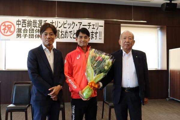 中西選手(中央)に花束を贈って健闘をたたえる加計理事長(左)と加計孝太郎学園長(右)