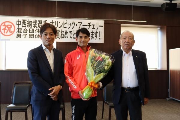 中西選手（中央）に花束を贈って健闘をたたえる加計理事長（左）と加計孝太郎学園長（右）