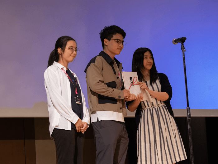 奨励金を授与されたユーシュエン・ルオ氏(左)、ヨンシュー・ヤン氏(中央)と、レビューボード(審査+プレゼンター)の中島 明日香氏(右)