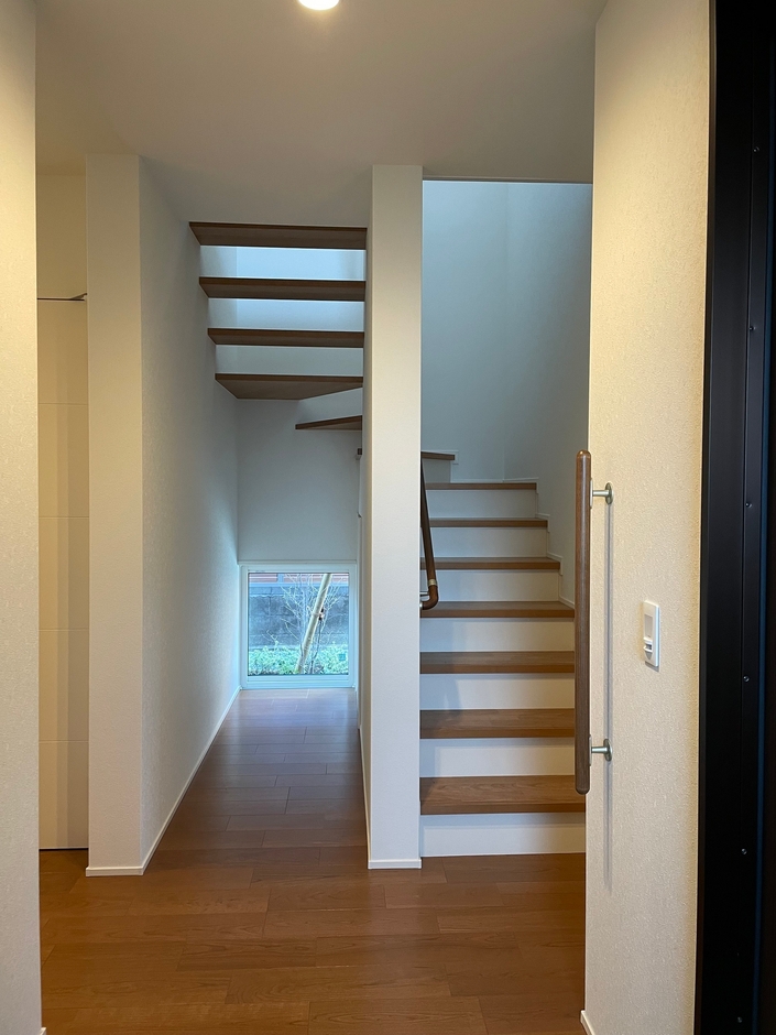 小窓がアクセントになっている階段　上半分はシースルーで下半分は収納に
