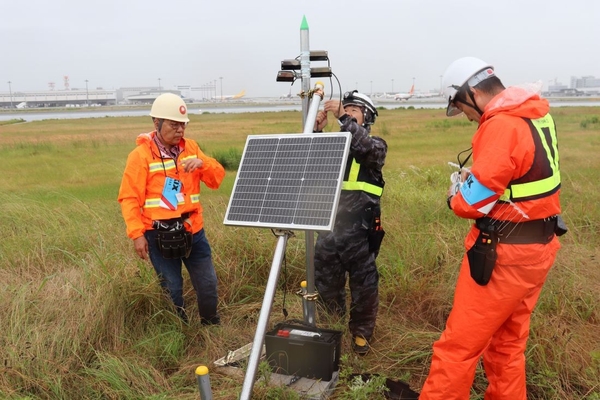 滑走路わきでバードソニックをくみ上げていく辻特坦教授（左）ら＝写真はいずれも関西国際空港で6月3日撮影