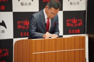 ▲協定書にサインする市長