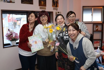 3月10日プレオープンに集まる友人と清水 則子(写真:中央色紙と花束を持つ女性)