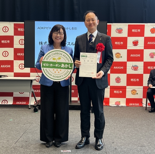 表彰状を手にする田深浩史執行役員(右)と丸谷明石市長