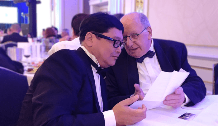 「金賞続出の鍵を握る謎の男」とテレビで紹介された株式会社Foods R&D代表取締役 安達 成明(左)がモンドセレクション審査委員長と意見交換をする様子