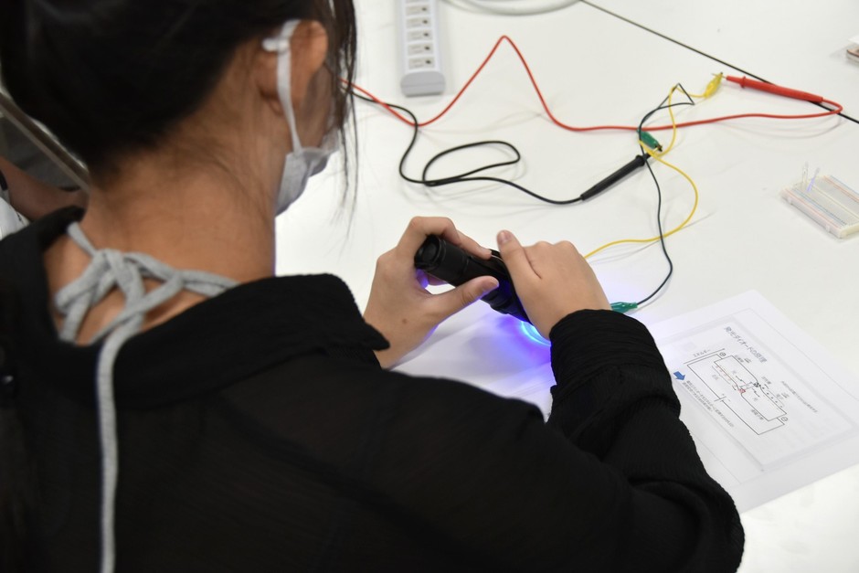 青色のLEDを照射して電気が流れることを測定する参加者