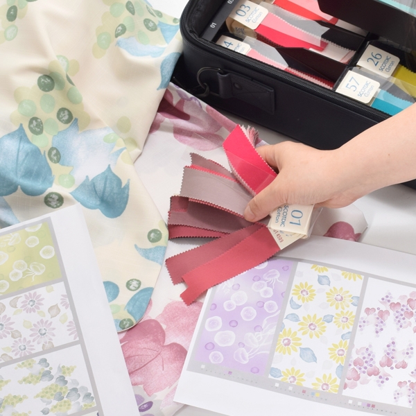 色チップを当てて検討する様子(図案は2023年版)