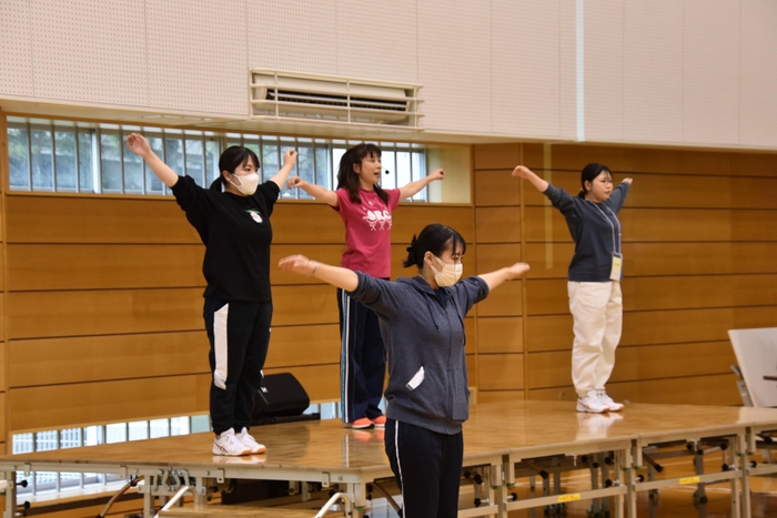 運動のお手本を見せる学生ら