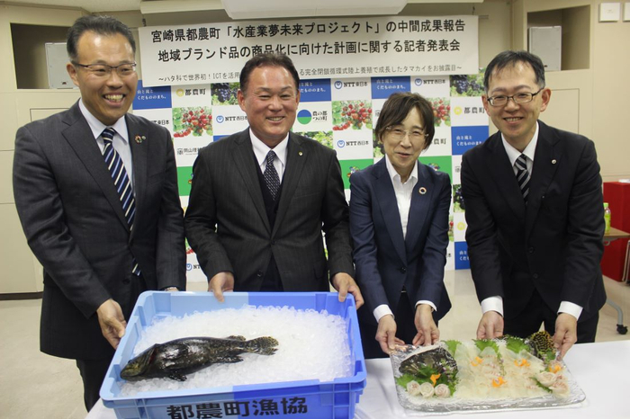 成長したタマカイを前に笑顔の（左から）小林担当部長、坂田町長、南副学長、大友副支店長