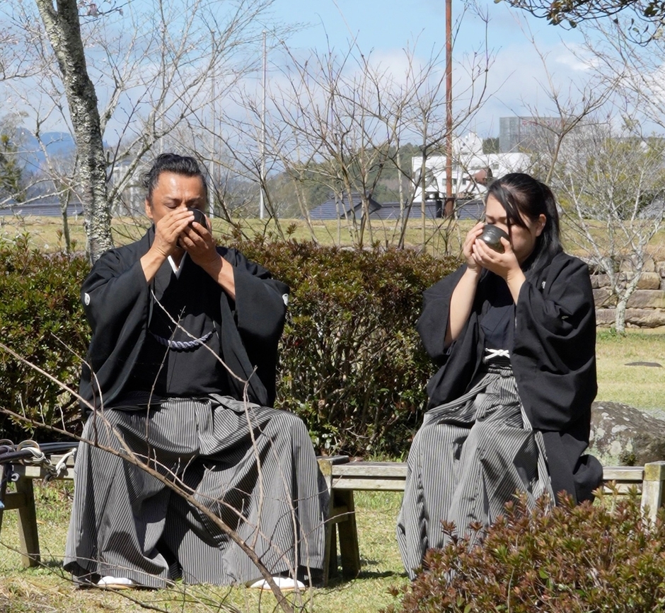 →三日月ノ城(人吉城・国史跡)に鎮座する相良神社で抹茶を召し上がる 兵法タイ捨流 第15代目宗家・上原エリ子さま(写真：右)、兵法タイ捨流 龍泉館館長・山本隆博さま