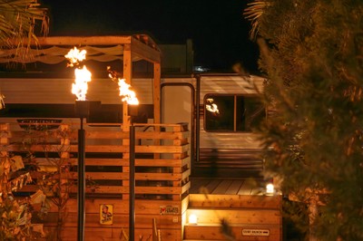 夜のトレーラーハウス。ガス灯の火と、屋根付きのBBQテラス