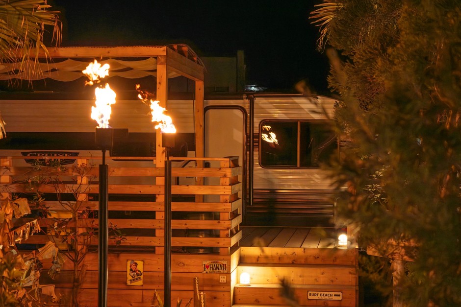 夜のトレーラーハウス。ガス灯の火と、屋根付きのBBQテラス