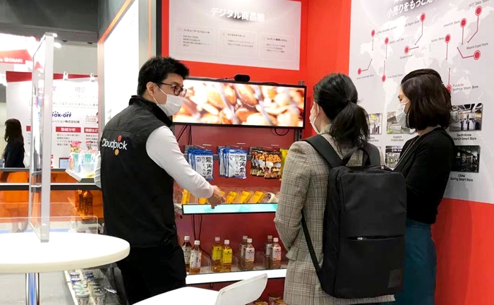デジタル商品棚についてスタッフが説明している様子