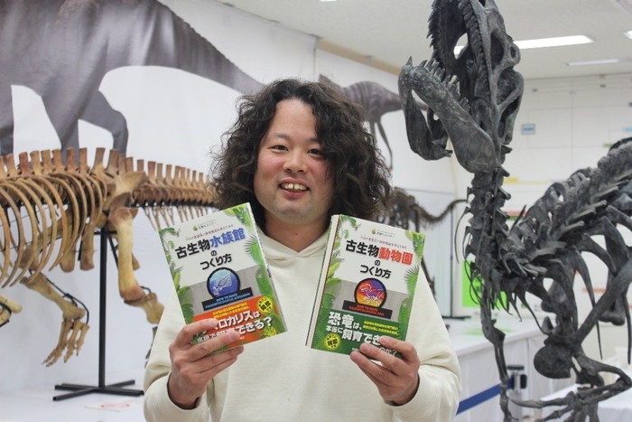 出版された2冊の本を手にする林准教授=理大の恐竜学博物館で