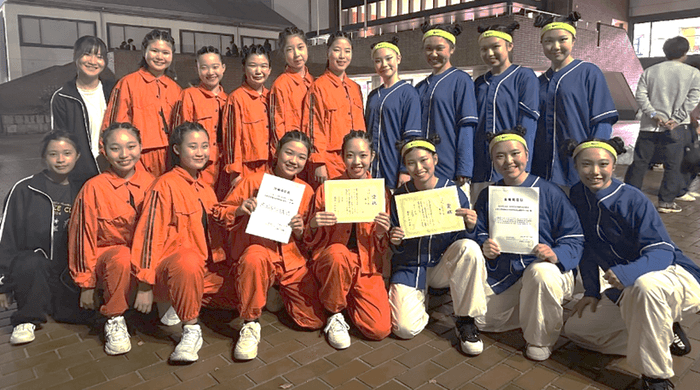  令和6年（2024年）11月のダンスドリル秋季競技大会（中国・四国大会）の様子　高校ダンス部（紺の衣装）、中学校ダンス部（オレンジ・黒の衣装）