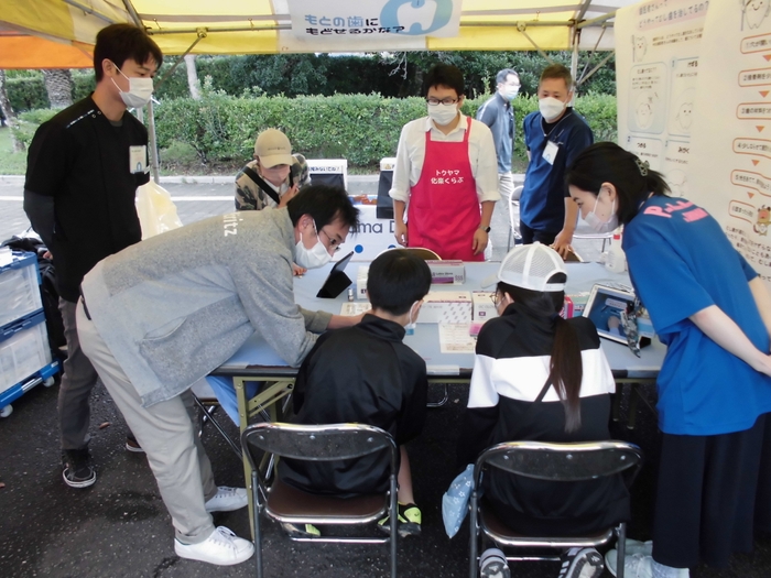 体験する子どもたちと説明する歯科医師