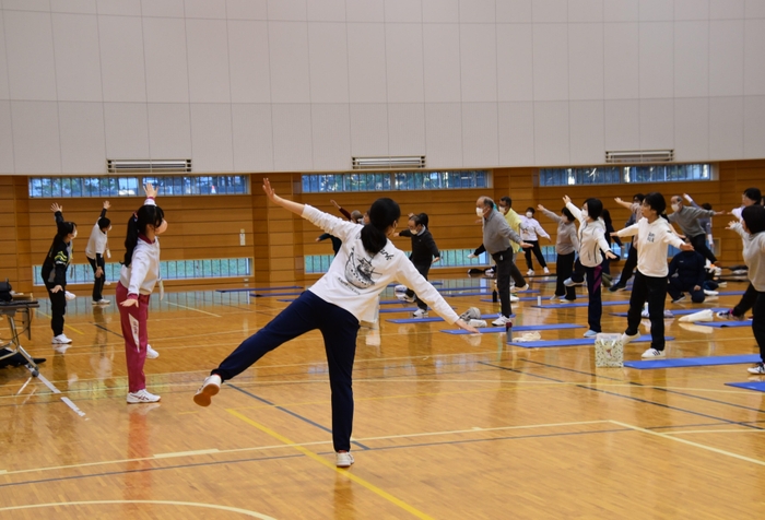 ストレッチなどで見本を示す学生