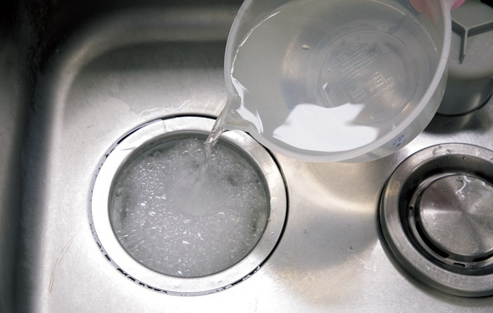 キッチンの排水口に重曹とクエン酸をふり入れてぬるま湯をコップ1杯。発泡しながら汚れを落とします