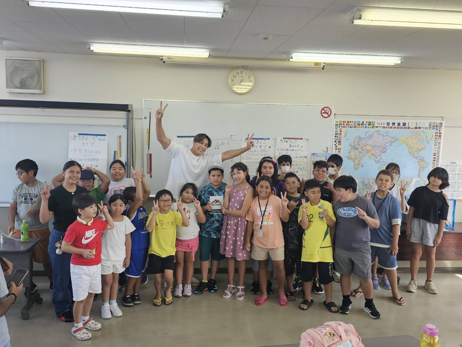 「日本語補修教室に通う子どもたちと笑顔で記念撮影する當間ローズ(湖西国際交流協会にて、2025年8月18日)」
