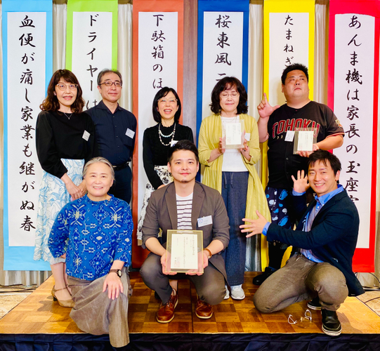 大賞を受賞したツナ好さん（写真 前列中央）と、選者・夏井いつき氏（同左）、司会の家藤正人氏（同右）