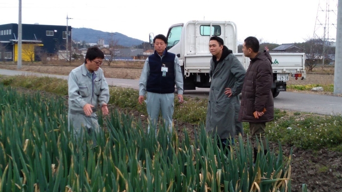 産地で説明を聞く料理人の方々