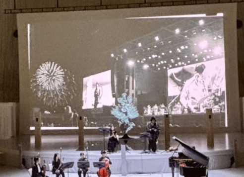 音楽劇「我ら地球人〜ダディとマザーの物語」公演より(スクリーンに9/26開催ライブ時の花火風景)