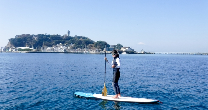 江ノ島の海でSUPスクールを体験する様子