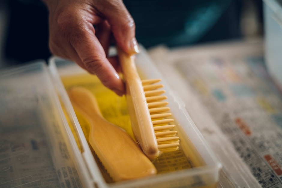 贅沢に椿油にブラシを浸す様子
