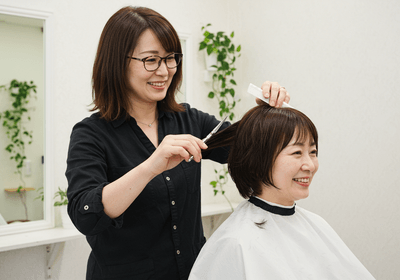 カット中の写真　アイリストとして活躍をしながら、スタイリストを目指せる