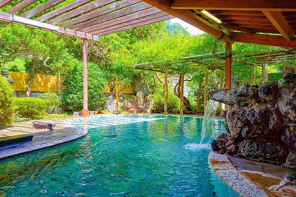 瓢箪型の石造りの大きな浴槽。積み上げた岩から滔々と流れ落ちる豊富な湯量と共にお楽しみください。(鹿教湯 藤館 野天風呂・文殊の湯)