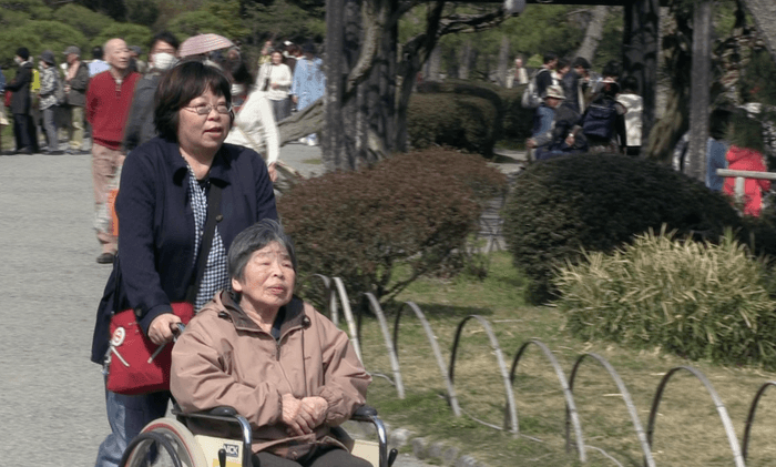 母の車椅子を押す関口監督
