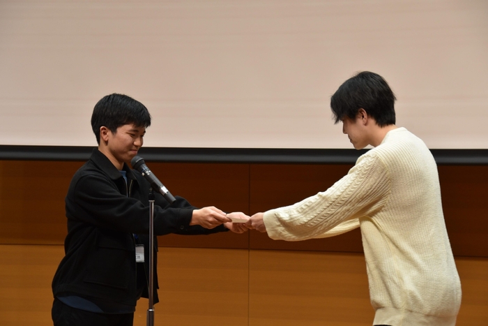 最優秀メンバー賞を渡す社本さん(左)