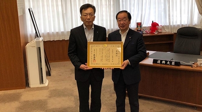 感謝状贈呈式にて 伊藤哲夫 近畿大学社会連携推進センター長(左)、渡辺博道 復興大臣