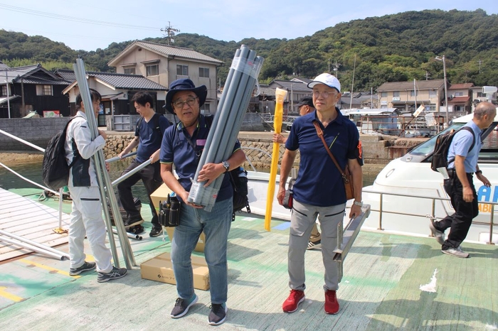 船で運び込んだ機材を真鍋島に陸揚げする辻教授（中央）ら一行