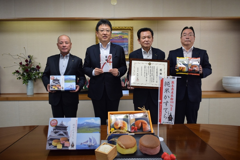 寄付金を送った丁代表理事会長(右から2人目)と、目録を受け取った大西市長(同3人目)