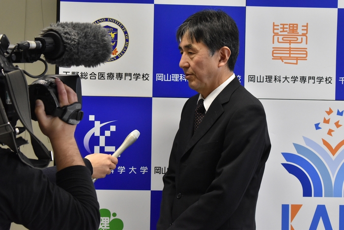 記者会見する田原校長