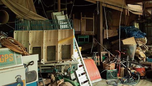 農業器具、機械、その他生活用品でごった返す作業場１階の様子。 物が多すぎて奥まで見渡せない(本文より)