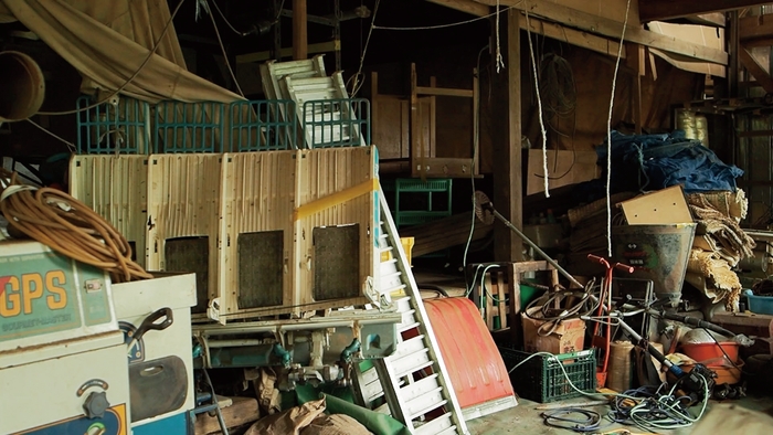 農業器具、機械、その他生活用品でごった返す作業場1階の様子。 物が多すぎて奥まで見渡せない(本文より)