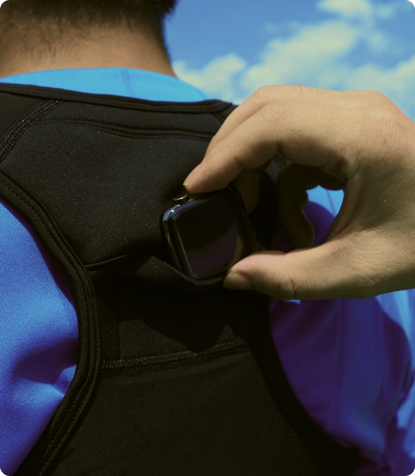専用スポーツベストの背中にアップルウォッチを入れるシーン