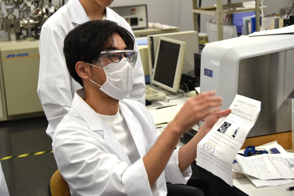 分析装置を説明する応用化学専攻の田浦大輔教授